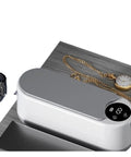 Totally Slick Portable Ultrasonic Cleaner For Sparkling Jewelry And Flawless Eyeglasses Hella Efficient Rechargeable Cleaning Pod on wooden surface with jewelry and watch.