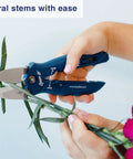 Hands using 4-In-1 Box Cutter And Package Opener Tool With Heavy Duty Scissors Retractable Blade And Screwdriver for cutting flowers