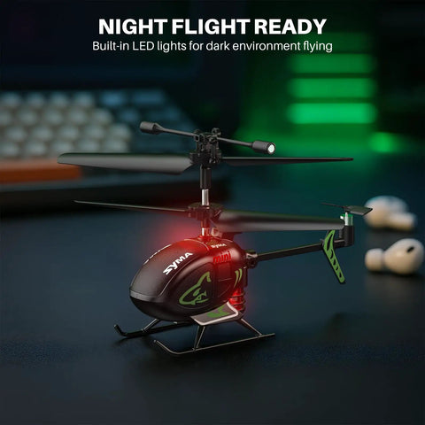 Palm Sized Mini RC Helicopter With Gyro Stabilizer And Altitude Hold for indoor night flight, LED lights on, desk background.