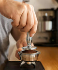 Using Heavyweight Dual Sided Espresso Tamper Made From Durable Aluminum With 48 Millimeter And 53 Millimeter Ends on portafilter