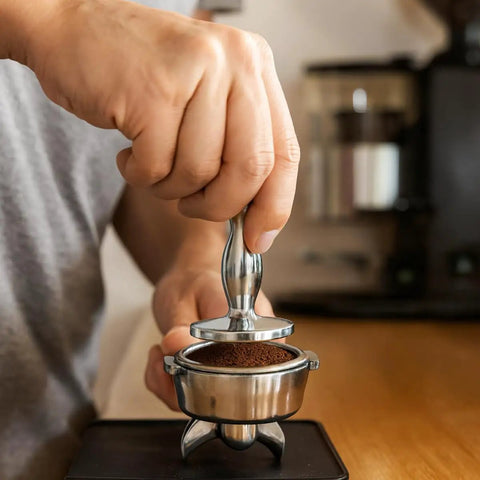 Using Heavyweight Dual Sided Espresso Tamper Made From Durable Aluminum With 48 Millimeter And 53 Millimeter Ends on portafilter