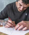 A person using Smooth Double Ended Markers For Piercing And Art Projects, 10 Piece Set With Bold And Fine Tips for drawing.