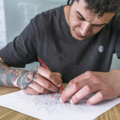 A person using Smooth Double Ended Markers For Piercing And Art Projects, 10 Piece Set With Bold And Fine Tips for drawing.