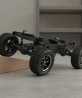 12-Scale RC Aluminum Alloy Chassis Kit for DIY Electric Car Build with sturdy black frame shown climbing a wooden ramp