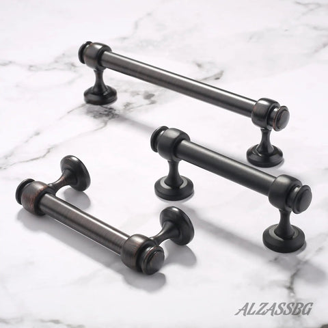 Three dark metal cabinet pulls on marble surface, matching description of 15 Pack Matte Black Cabinet Pulls Go-To 3 Inch Center-To-Center Straight Bar Handles for Cabinets and Drawers Kitchen Hardware AL3082MB Durable Solid Construction with Easy Install, Modern Finish for Cabinets, Furniture and More.