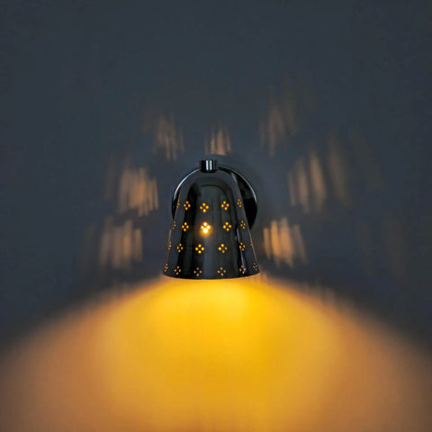 Silver Brass Wall Sconce, Mid Century Cone Lamp, Perforated Spotlight illuminating unique shadows on the wall.