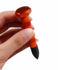 Close-up of DIY Paintless Dent Repair Kit part, an orange tap down pen with plastic tip held in hand for small dings and hail damage.