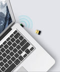 USB WiFi Adapter for PC N150 Nano Size Dongle plugged into laptop, emitting wireless signal, ideal for Windows Mac Linux use.
