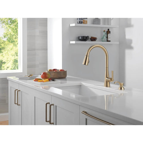 Modern Single Handle Kitchen Sink Faucet With Pull Down Spray Head And Built In Soap Dispenser, Magnetic Self Docking, Brushed Gold Finish in stylish kitchen setting.