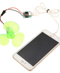 Portable Mini Wind Generator For Emergency Power And Phone Charging with green blades connected to smartphone via USB cable.