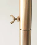 Close-up of golden metal connector on Heavy Duty Industrial Clothes Rack With Golden Floor Standing Coat Stand For Bedroom Or Entryway Dope Durable Iron Art Clothing Display Sturdy Storage Solution For Everyday Wardrobe Organization.