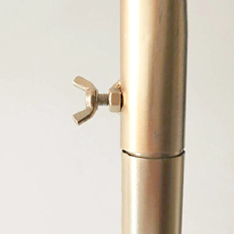Close-up of golden metal connector on Heavy Duty Industrial Clothes Rack With Golden Floor Standing Coat Stand For Bedroom Or Entryway Dope Durable Iron Art Clothing Display Sturdy Storage Solution For Everyday Wardrobe Organization.