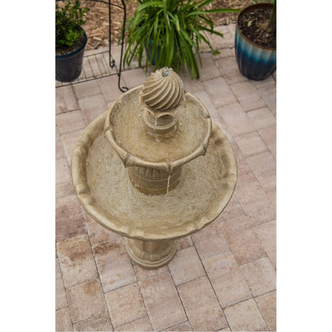 Stone outdoor water fountain in brick patio surrounded by potted plants, top view, artistic garden decoration, water splashing detail
