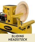 Powermatic 20x20 variable-speed wood lathe with sliding headstock; yellow machine and large wooden turning blank mounted