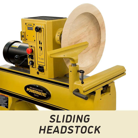 Powermatic 20x20 variable-speed wood lathe with sliding headstock; yellow machine and large wooden turning blank mounted