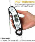 Hand holding Digital Instant Read Meat Thermometer with 4.6 inch folding probe under running water demonstrating IP67 waterproof feature