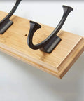 Close-up of Heavy Duty Wall Mount Coat Rack With Seven Rugged Zinc Hooks, showcasing metal hooks on a wooden base.