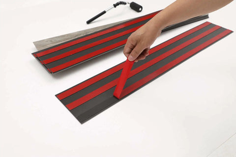 Applying adhesive strip to Vinyl Wall Planks Self-Adhesive Peel And Stick Panels For Walls Ebony Black 12 Pcs (18 Sq Ft) Box