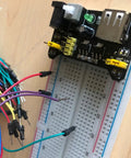 DIY Breadboard Kit With Power Supply Module And 65 Jumper Wires 40 Pin 20 Cm Leads Pro Grade Prototyping For 3.3V And 5V Electronics Starter Friendly For Class Lab Or Home Projects Portable And Easy To Use. breadboard with power module and jumper wires on desk