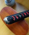 Close-up of Dope DIY Tsuka Sword Handle Kit ten point two inch for samurai katana with black and red silk Ito wrap on hardwood core.