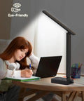 LED Desk Lamp With Built In Power Strip, 3 Outlets And 4 USB Ports Including 2 USB C next to a person using a laptop
