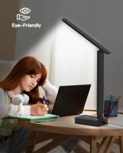 LED Desk Lamp With Built In Power Strip, 3 Outlets And 4 USB Ports Including 2 USB C next to a person using a laptop