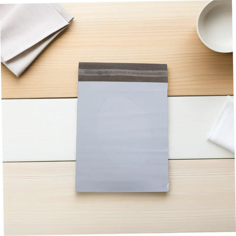 White Poly Mailer Bags 100 Pack 10x14 Inch Waterproof Self Seal Envelopes for Shipping clothes and mailing supplies on table