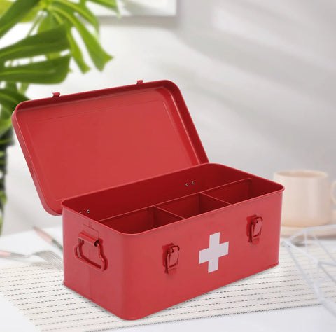 Red metal first aid kit box with white cross; open lid shows divided interior with three compartments and side handles