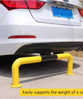 Car backed against U Shaped Steel Pipe Wheel Stop With Anti Collision Round Parking Post in yellow and black, floor mounted.