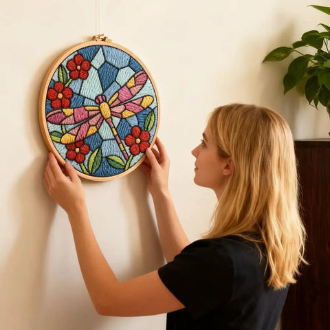 Woman hanging Dragonfly Punch Needle Kit For Adults Beginners Colorful Flower Embroidery Starter Set with hoop on wall.