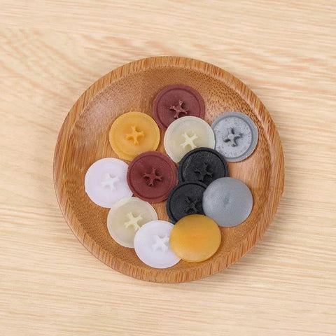 Colorful plastic screw cap covers on a wooden plate