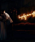 Groom and bride in front of Happily Ever After Neon Sign LED Light For Weddings And Bridal Decor Custom Neon Wall Hanging Hand Crafted Accent With Warm White Glow 80 Cm Size Vibe Ready Wedding Sign on wooden wall with red couch