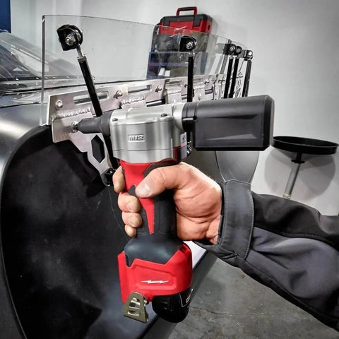 Close-up of Heavy Duty 10.75 Inch M12 Cordless Rivet Tool Kit with a hand gripping it, designed for efficient steel bonding.