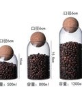 Lock In Freshness Straight Up With This Round Glass Tea Canister Boasting A Tight Cork Seal And Heat Resistant Build Ideal For Storing Coffee Beans Sugar Salt Or Loose Leaves While Looking Sharp On Counters: three sizes, cork tops, filled with coffee beans.
