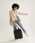 Woman holding Underseat Rolling Work Bag With Laptop Sleeve And Botanical Paisley Print For Commuters, Softside Travel Ready Tote.