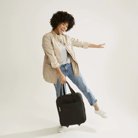Woman holding Underseat Rolling Work Bag With USB Charging Port, ID Window And Two Quick-Access Zip Pockets, Lightweight Black Carry-On