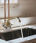 Two Handle Laundry Faucet With 7 Inch Rough Brass Swivel Spout Drip Free No Fuss Quarter Turn Valve Garden Hose Connection Removable Aerator For Easy Reach To Clean Every Side Of Your Wash Tub in a laundry sink.