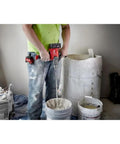 Person using 18V Cordless Mud Mixer Bare Tool for Drywall Mud Plaster and Concrete Projects with buckets and materials