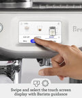 User interacting with the touchscreen of the Absolute Game Changing Slick Espresso Machine In Damson Blue.