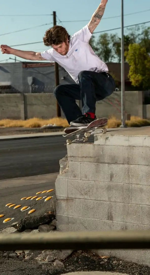 Skateboarder performing trick on street with California Roll 60mm 78A White Skateboard Longboard Wheels, built for park ramps and street cruisin