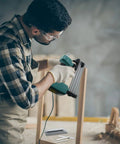 Man using Heavy Duty 1400 Piece 18 Gauge Brad Nails Kit For Pneumatic And Electric Nailers With Seven Flexible Lengths For Woodworking and Trim Work.