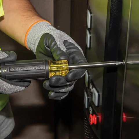 Person using Grab And Go Multi Bit Tamperproof Screwdriver Kit with Twenty Six Onboard Bits and Quarter Inch Nut Driver in elevator panel.