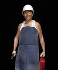 Man wearing Heavy Duty Cowhide Welding Apron That Is Totally Fireproof And Spark Shielded For Pros Who Need Serious Fire Protection During Intense Soldering Jobs In The Shop, holding tools.