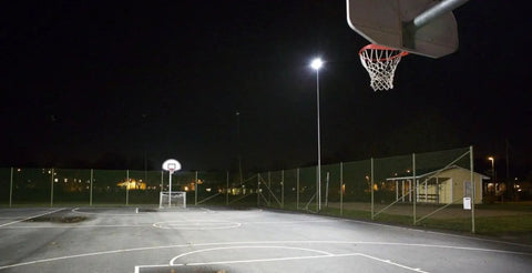 Basketball court illuminated by 100W Solar Flood Light With Remote Control Dusk To Dawn Outdoor Lamp 324 LEDs 5000 Lumen Brightness