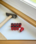8 Pack Woodworking Planing Stoppers For Workbench Dog Holes Red Aluminum Alloy on table with hammer