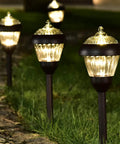 4 Pack High Lumen Metal Solar Pathway Lights with 2 Bright LED Per Light illuminating garden path at night