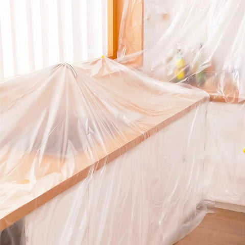 20 Pack Heavy Duty Pro Grade Plastic Drop Cloths 9x12 Feet For Painting covering furniture in a room for protection.