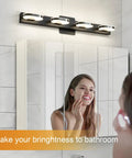 Woman using mirror under Modern LED Vanity Light 3-Head Wall Sconce For Bathroom, 19 Inch Black Finish, lit natural white light.