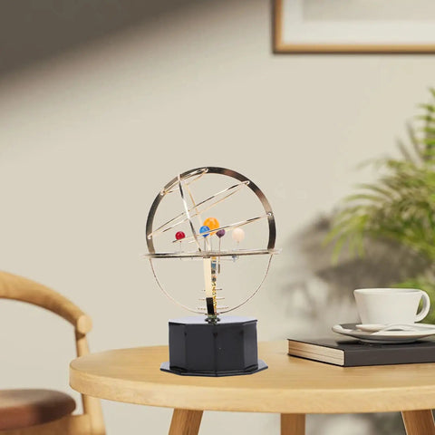 Gold Tone Solar System Model Decoration With Iron And Plastic Grand Orrery on a wooden desk with plants and a cup