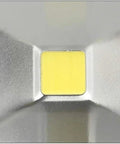 Close-up view of LED chip in aluminum housing for 100W floodlight, featuring a yellow light source for outdoor waterproof use.